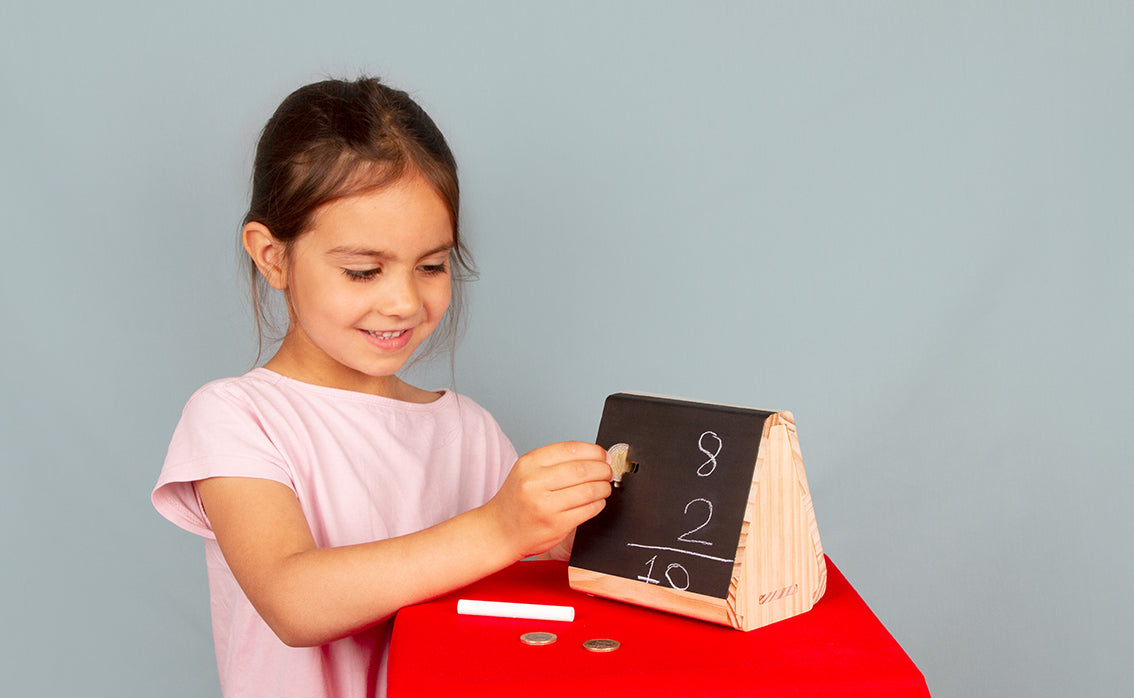 Child slotting in coins into the money box